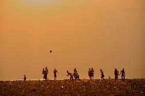 Youth Play A Game Of Football By The Ocean At Sunset In Paruthiyoor