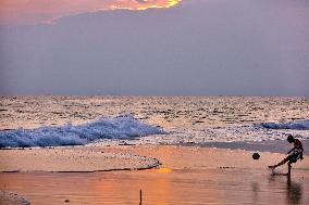 Youth Play A Game Of Football By The Ocean At Sunset In Paruthiyoor