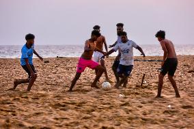 Youth Play A Game Of Football By The Ocean At Sunset In Paruthiyoor