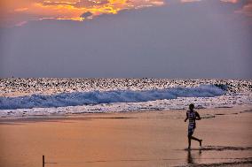 Youth Play A Game Of Football By The Ocean At Sunset In Paruthiyoor