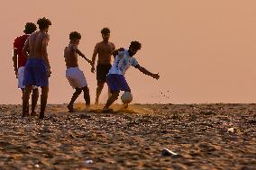 Youth Play A Game Of Football By The Ocean At Sunset In Paruthiyoor