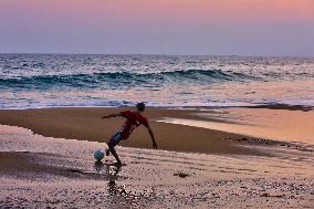 Youth Play A Game Of Football By The Ocean At Sunset In Paruthiyoor