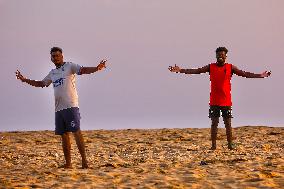 Youth Play A Game Of Football By The Ocean At Sunset In Paruthiyoor