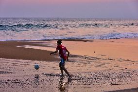 Youth Play A Game Of Football By The Ocean At Sunset In Paruthiyoor