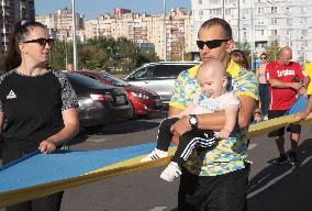 Run with Ukrainian flag in Kyiv