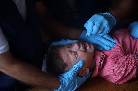 Palestinian Child Receives Polio Vaccine at UN Center in Gaza Amid Conflict