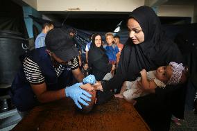 Palestinian Child Receives Polio Vaccine at UN Center in Gaza Amid Conflict