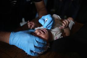 Palestinian Child Receives Polio Vaccine at UN Center in Gaza Amid Conflict