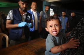 Palestinian Child Receives Polio Vaccine at UN Center in Gaza Amid Conflict