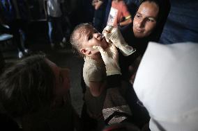 Palestinian Child Receives Polio Vaccine at UN Center in Gaza Amid Conflict