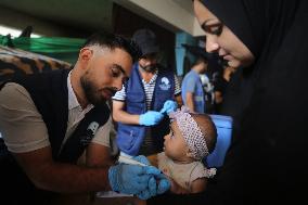 Health Worker Marks Finger of Palestinian Child Vaccinated Against Polio in Gaza Amid Conflict