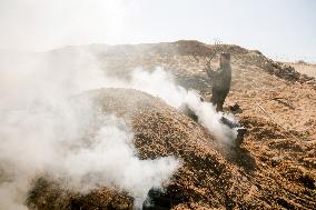 Workers Labor In A Coal-Making Pit - Gaza