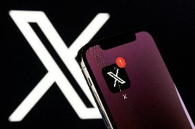 X App Icon On IPhone With Logo In Background