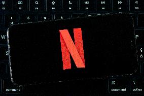 Netflix Logo Displayed On IPhone With MacBook Air Keyboard Background