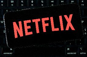 Netflix Logo Displayed On IPhone With MacBook Air Keyboard Background