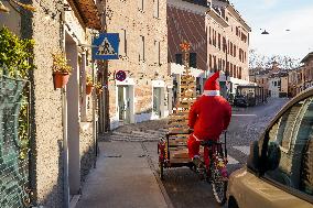 Santa Claus And A Wooden Christmas Tree On A Bicycle