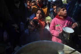 Gaza Children Wait To Receive A Hot Meal Of Food