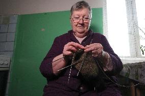 Evacuees from Kharkiv region knit for Ukrainian military