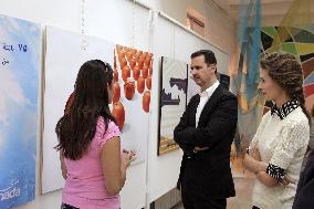 Syrian president Bashar El Assad and his wife Asma visit an exhibition in Damascus