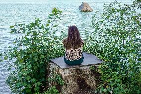 Woman Reflecting. A Moment Of Solitude By The Lake