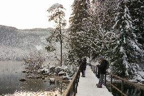 People Hiking Around The Bavarian Alpine Lake Eibsee In Winter