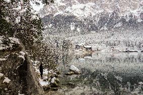 People Hiking Around The Bavarian Alpine Lake Eibsee In Winter