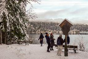 People Hiking Around The Bavarian Alpine Lake Eibsee In Winter