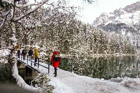 People Hiking Around The Bavarian Alpine Lake Eibsee In Winter