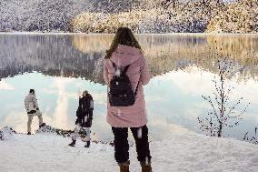 People Hiking Around The Bavarian Alpine Lake Eibsee In Winter