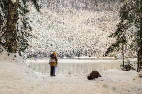 People Hiking Around The Bavarian Alpine Lake Eibsee In Winter