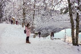 People Hiking Around The Bavarian Alpine Lake Eibsee In Winter