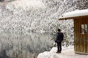 People Hiking Around The Bavarian Alpine Lake Eibsee In Winter