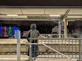 Passengers Waiting During Sleet At A Train Station On Munich