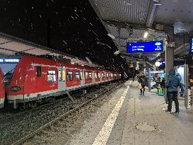 Passengers Waiting During Sleet At A Train Station On Munich