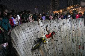 Two Circus Men Perform On The Wall Of Death