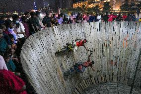 Two Circus Men Perform On The Wall Of Death