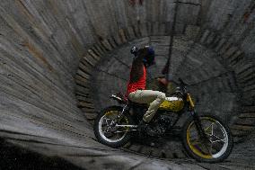 Two Circus Men Perform On The Wall Of Death