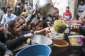 Palestinians Receive Food From A Charity Kitchen - Gaza