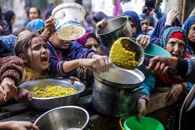 Palestinians Receive Food From A Charity Kitchen - Gaza