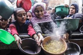 Palestinians Receive Food From A Charity Kitchen - Gaza