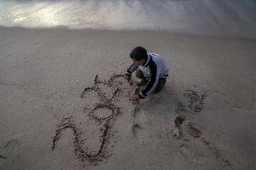 A Palestinian Boy Writes 2025 at A Beach - Gaza