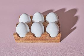 Minimalist Composition: White Eggs In A Wooden Holder