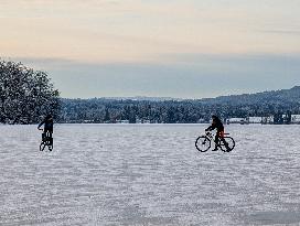 Boys Cycling On Frozen Bavarian Lake Staffelsee