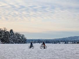 Boys Cycling On Frozen Bavarian Lake Staffelsee