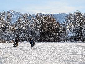 Boys Cycling On Frozen Bavarian Lake Staffelsee