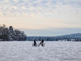 Boys Cycling On Frozen Bavarian Lake Staffelsee