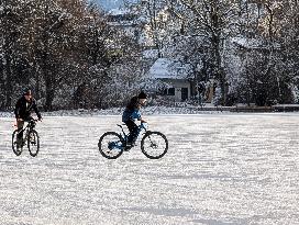 Boys Cycling On Frozen Bavarian Lake Staffelsee