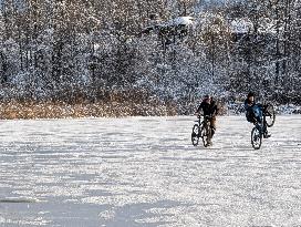 Boys Cycling On Frozen Bavarian Lake Staffelsee