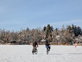 Boys Cycling On Frozen Bavarian Lake Staffelsee