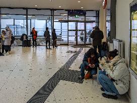 Travelers Waiting For Their Train In A Station Hall